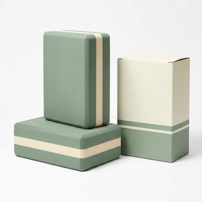 White background product photo of two sage and cream yoga blocks and logo-free packaging