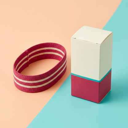 Raspberry and cream exercise loop lying oval beside matching blank ivory raspberry turquoise carton
