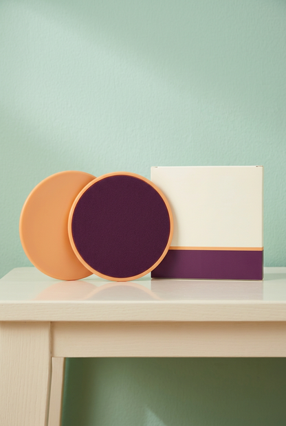 Small Kit Thoughtful Practice: two exercise slider discs and matching completely blank carton on cream bench